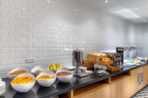 ein Buffet mit Schalen Essen auf der Theke in der Unterkunft Holiday Inn Express - London Heathrow T4 by IHG in Hillingdon
