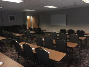 uma sala de conferências com mesas e cadeiras e um ecrã em Holiday Inn Express Hotel & Suites Laurinburg, an IHG Hotel em Laurinburg