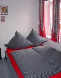 a bed with black and red pillows in a bedroom at Hotel zur Eiche in Oberthal