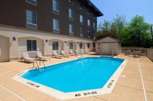 a large swimming pool with chairs and a building at Holiday Inn Express Philadelphia NE - Langhorne, an IHG Hotel in Langhorne