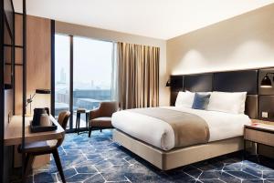 a hotel room with a large bed and a large window at Hyatt Regency Manchester in Manchester