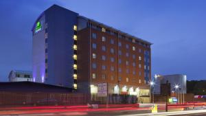 a large building with lights on the side of it at Holiday Inn Express London Limehouse, an IHG Hotel in London