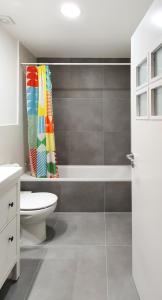 a bathroom with a tub and a toilet and a shower curtain at AT Compañía 100 m2 2 WC in Pamplona