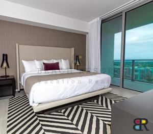 - une chambre avec un grand lit et une grande fenêtre dans l'établissement HYDE Beach House Apartments, à Hollywood
