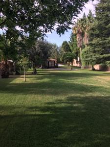 un parque verde con árboles y un gran campo de césped en Shangri la en Mendoza