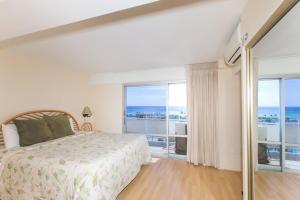 una camera con un letto e una grande finestra di Ilikai Tower 943 Condo - Walk to the Beach, Shops & Restaurants! a Honolulu