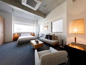 a living room with two beds and a couch at Hotel Mei Fukuoka Tenjin in Fukuoka