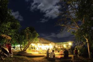 a group of people sitting outside of a building at night at Dreamhome Chiangdao in Chiang Dao