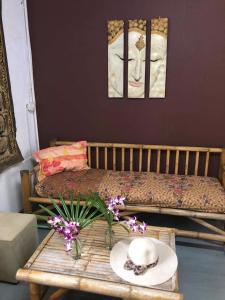 Cette chambre comprend une table avec un chapeau et des fleurs. dans l'établissement Lanta Complex, à Ko Lanta