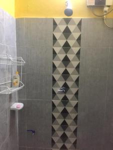 - une douche avec un mur carrelé noir et blanc dans l'établissement Lanta Complex, à Ko Lanta