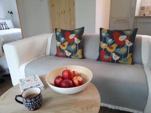 a bowl of apples on a table in front of a couch at Estuary View in Machynlleth