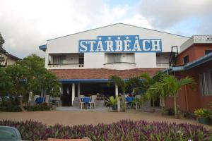 gwiazda budynku plażowego z krzesłami i stołami przed nim w obiekcie Star Beach Guest House w Negombo