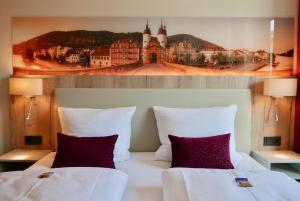 a hotel room with a bed and a painting on the wall at Rafaela Hotel Heidelberg in Heidelberg