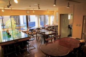 uma sala de jantar com mesas e cadeiras e um balcão em City Pension Tommy Rich Inn Kyoto em Quioto