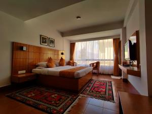 a hotel room with a bed and a large window at Hotel Tarayana in Gangtok