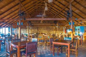 una sala da pranzo con tavoli e sedie in legno di COCONUT BEACH LODGE a Trincomalee
