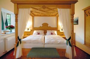 a bedroom with a four poster bed with a canopy at Alpenhof in Gauting