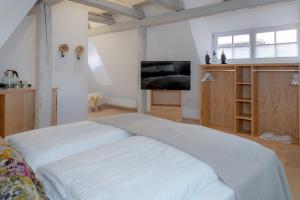 a living room with a bed and a television at hezelhof´s Hexenhäuschen in Dinkelsbühl
