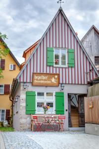 ein rot-weißes Gebäude mit einem Tisch davor in der Unterkunft hezelhof´s Hexenhäuschen in Dinkelsbühl