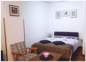 ein Schlafzimmer mit einem Bett, einem Tisch und einem Stuhl in der Unterkunft Apartments Bosco in Risovac