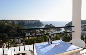 a table with a bottle and glasses on a balcony at Menorca Bonavista in Cala Galdana