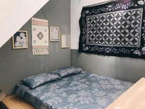 a bedroom with a bed and a rug on the wall at 醒覺旅人-訂房後需聯繫轉帳 in Tainan