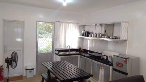 a kitchen with a sink and a table in it at 2BR townhouses good for 12pax each & NETFLIX & 100Mbps WIFI & pool resort 2min walk & 3km outside Pico de Loro Cove & Calayo Cove - with Endorsement for Pico de Loro Cove daytour & Boat-Tour & Island Hopping assistance in Nasugbu