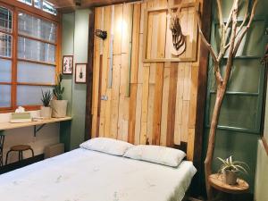 ein Schlafzimmer mit einer Holzwand und einem Bett in der Unterkunft 醒覺旅人-訂房後需聯繫轉帳 in Tainan