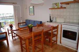 a kitchen with a wooden table and chairs and a stove at Menorca Bonavista in Cala Galdana