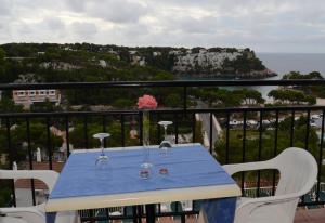 a blue table on a balcony with a view of the ocean at Menorca Bonavista in Cala Galdana