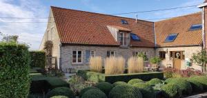 una casa antigua con un jardín delante de ella en Gasthof Schraevenacker, en Oostvleteren