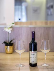 a bottle of wine and two wine glasses on a table at Belly2 in Vračar (historical)