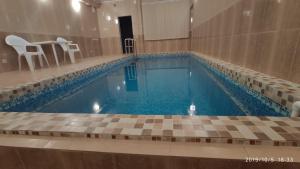 a swimming pool with blue water in a building at Gostevoy Dom Na Rybatskoy in Ryazan