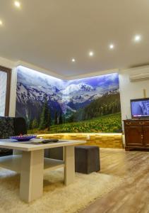 ein Wohnzimmer mit einem großen Wandbild eines Berges in der Unterkunft Stan SK in Pale