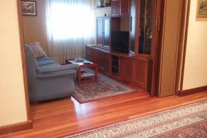 uma sala de estar com uma cadeira e uma televisão em Casa en Urdaibai para disfrutar la zona E-BI00235 em Elejalde