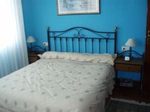 um quarto com uma cama com uma parede azul em Casa en Urdaibai para disfrutar la zona E-BI00235 em Elejalde