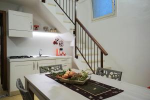 a kitchen with a table with a bowl of fruit on it at Aretè Apartments in Lecce