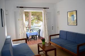 a living room with a blue couch and a table at Menorca Bonavista in Cala Galdana