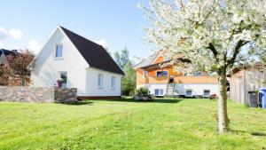 ein weißes Haus mit einem Baum im Hof in der Unterkunft Ferienhaus in Kuehlungsborn in Kühlungsborn