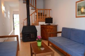 a living room with a blue couch and a fireplace at Menorca Bonavista in Cala Galdana
