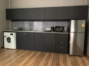 a kitchen with a refrigerator and a washing machine at PoolVilla Chaam NL in Cha Am