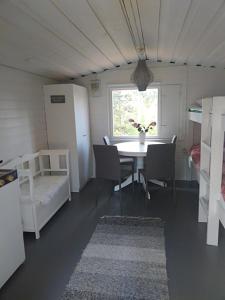 een kamer met een tafel en stoelen en een raam bij Lemmenjoki Camping EcoCabins in Lemmenjoki