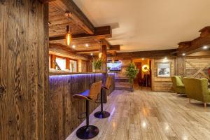 un bar con paredes de madera y taburetes en una habitación en Haus Magnushof, en Eisenberg