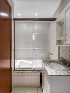 a bathroom with a tub and a sink at Hotel Cardozo in Parobé