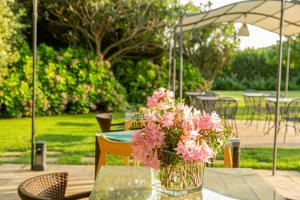 a vase of pink flowers sitting on a table at Wine Resort Ledà d'Ittiri in Alghero