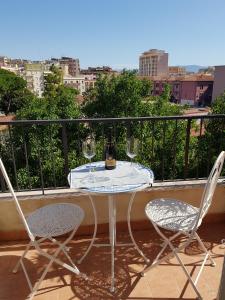 una mesa y 2 sillas con copas de vino en el balcón en San Lucifero Home & Relax - IUN 1871 en Cagliari