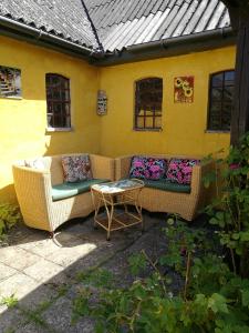 a patio with two wicker couches and a table at Havehøjegaard in Borre