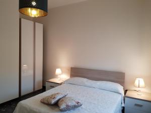 1 dormitorio con 1 cama con 2 mesas y 2 lámparas en San Lucifero Home & Relax - IUN 1871 en Cagliari
