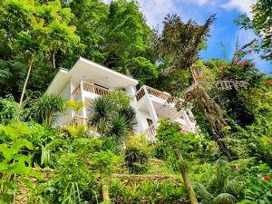 una casa blanca rodeada de árboles y plantas en Cocoloco Beach Resort, en Boracay