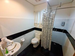 a bathroom with a toilet and a sink and a shower at Cocoloco Beach Resort in Boracay